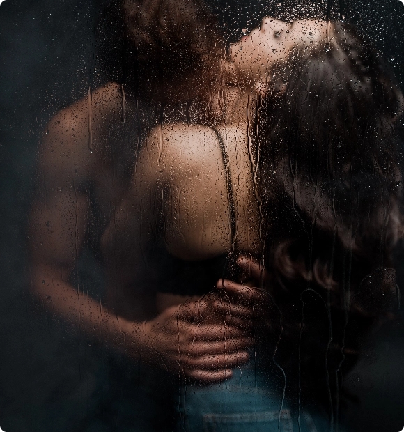 sexy-couple-hugging-and-kissing-behind-wet-glass